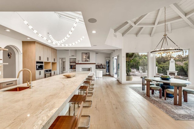 7102 Via De Maya, Rancho Santa Fe, CA 92067 - kitchen featuring a sink, beam ceiling, a chandelier, stainless steel oven, and light wood-type flooring