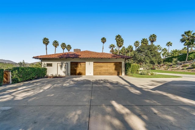 7102 Via De Maya, Rancho Santa Fe, CA 92067 - view of front of house featuring a tiled roof, stucco siding, a chimney, a garage, and concrete driveway