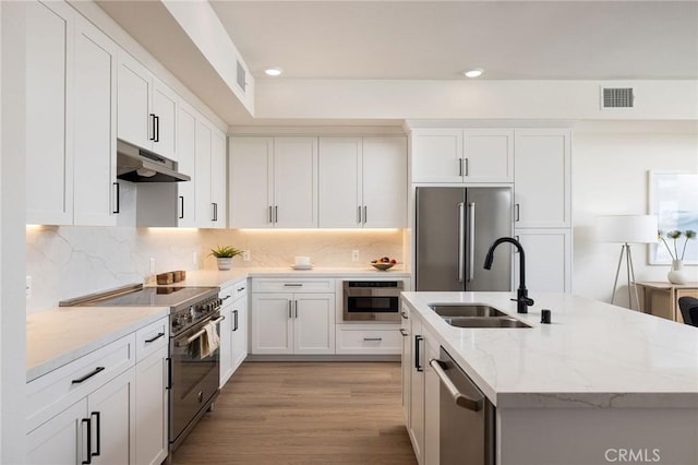 414 Main Unit 230, Huntington Beach, CA 92648 - kitchen with an island with sink, a sink, premium appliances, under cabinet range hood, and visible vents