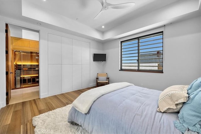 bedroom with a closet, a ceiling fan, wood finished floors, and recessed lighting