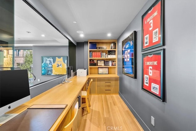 interior space featuring light wood-type flooring, built in study area, baseboards, and recessed lighting