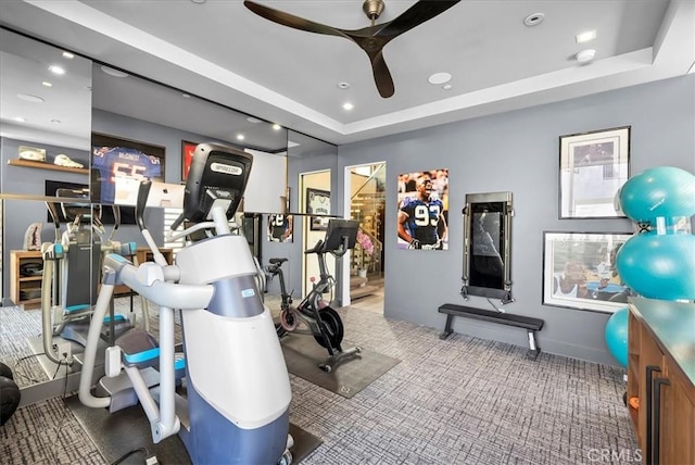 exercise room with a ceiling fan, recessed lighting, and a raised ceiling