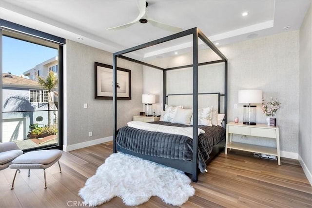 bedroom with wallpapered walls, baseboards, and wood finished floors