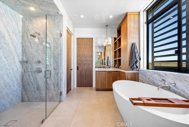 full bathroom with a freestanding bath, a marble finish shower, vanity, and tile patterned floors