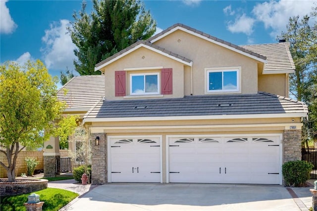 view of front of property with stone siding, concrete driveway, fence, and an attached garage