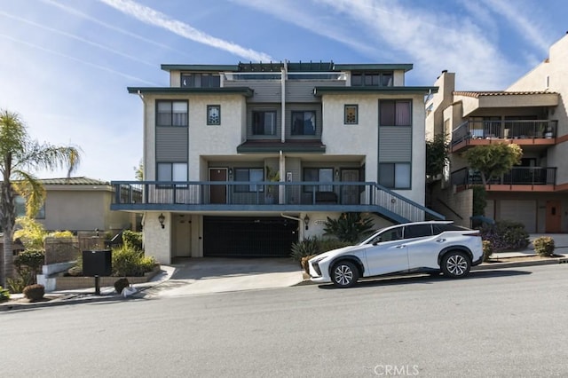 view of front of house featuring concrete driveway, an attached garage, and stucco siding