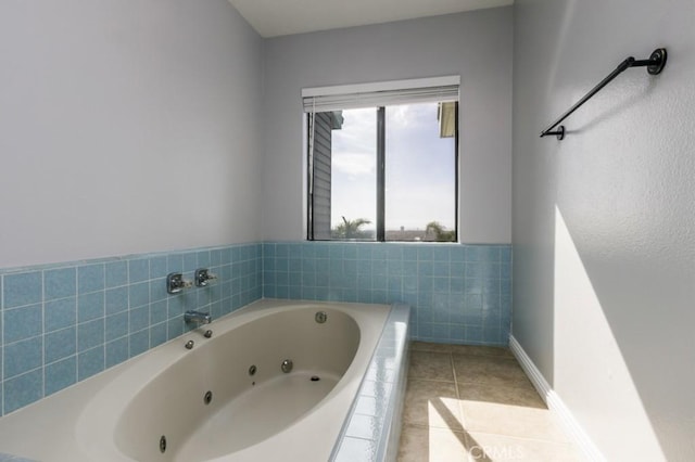 full bath featuring baseboards, a tub with jets, and tile patterned floors