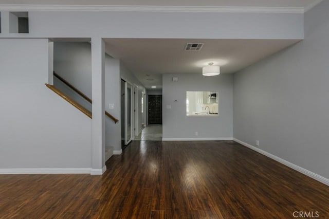 spare room featuring visible vents, stairway, baseboards, and wood finished floors