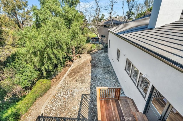 view of side of property featuring metal roof and stucco siding