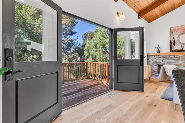 doorway to outside with lofted ceiling with beams, wood ceiling, wood finished floors, and visible vents