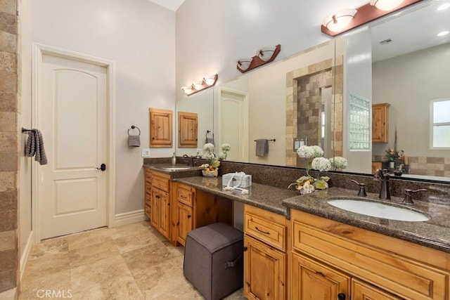 full bath featuring double vanity, visible vents, walk in shower, and a sink