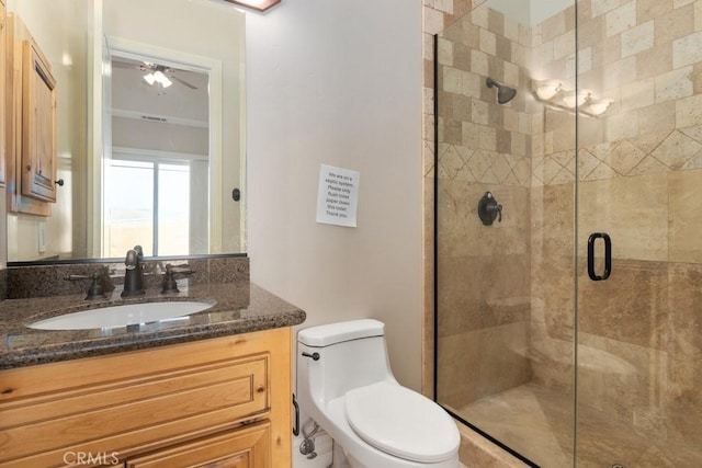 full bathroom with a ceiling fan, a shower stall, toilet, and vanity