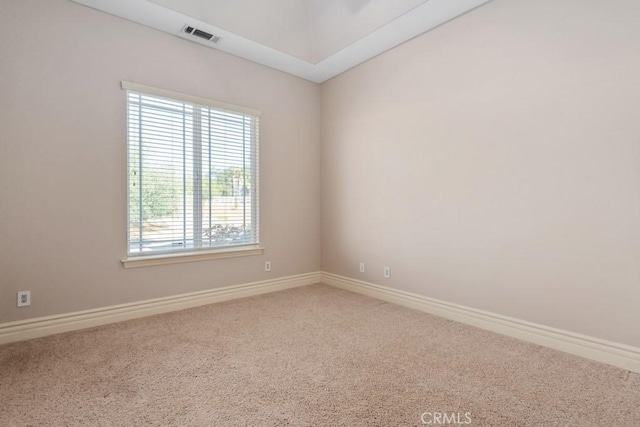 carpeted spare room featuring visible vents and baseboards