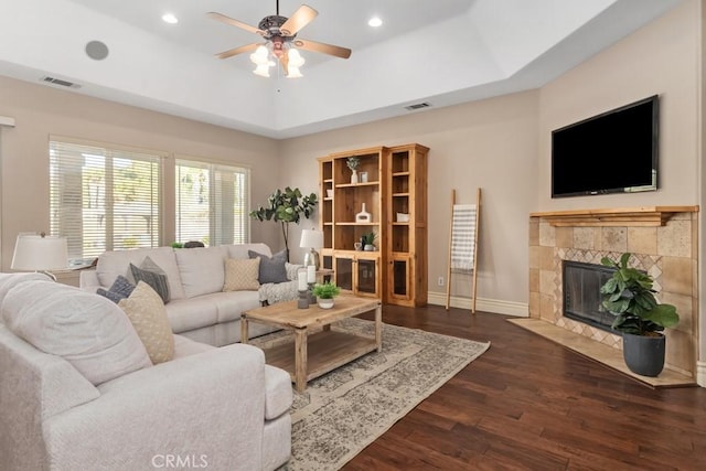 living area with visible vents, dark wood finished floors, and a raised ceiling