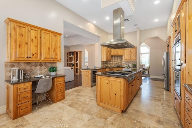 kitchen with beverage cooler, baseboards, island range hood, arched walkways, and stainless steel appliances