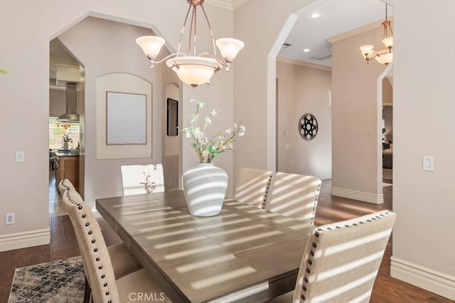 dining room featuring baseboards, a chandelier, arched walkways, and wood finished floors