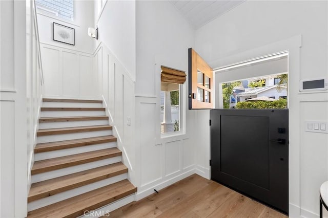 interior space featuring wood finished floors, a decorative wall, and stairs