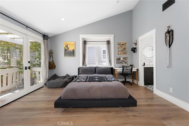 bedroom featuring french doors, vaulted ceiling, wood finished floors, access to outside, and baseboards