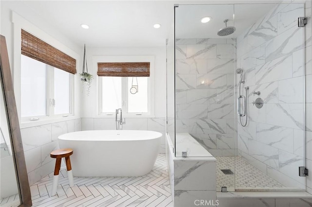 full bathroom featuring a stall shower, a freestanding bath, tile walls, and recessed lighting