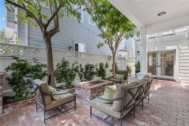 view of patio featuring an outdoor living space with a fire pit, french doors, and a fenced backyard