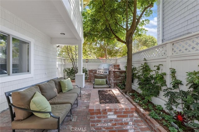 view of patio / terrace with exterior kitchen, a fenced backyard, grilling area, and an outdoor hangout area