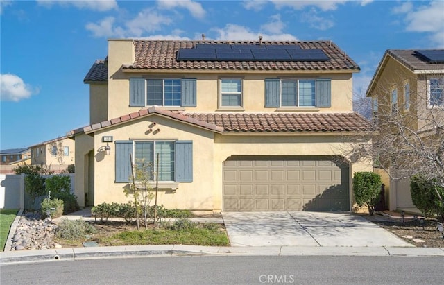 view of front facade with concrete driveway, a tile roof, solar panels, and stucco siding