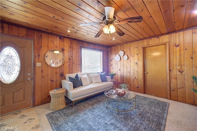 living area with wooden ceiling, ceiling fan, and wooden walls