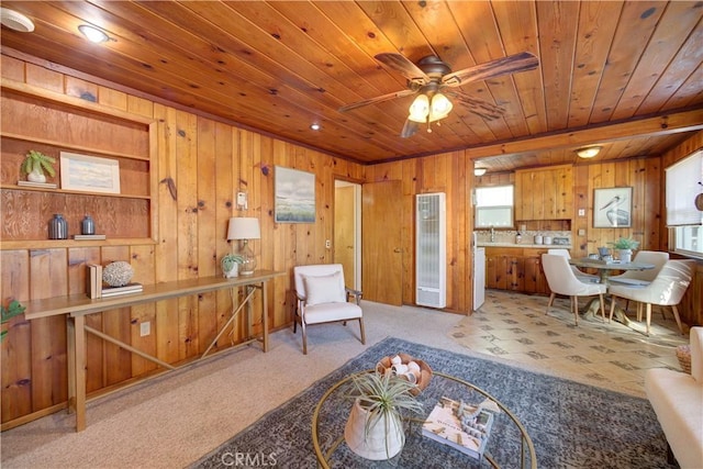 interior space with carpet, wooden ceiling, a ceiling fan, and wooden walls