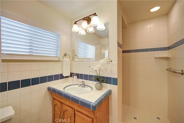 full bath featuring vanity, walk in shower, and tile walls