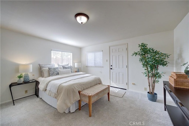 bedroom featuring light carpet and baseboards