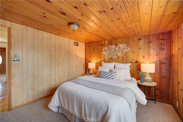 carpeted bedroom featuring wooden ceiling, wood walls, and baseboards