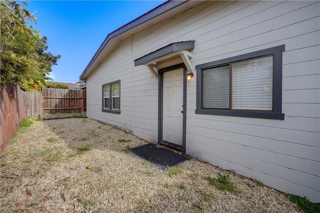 doorway to property featuring fence