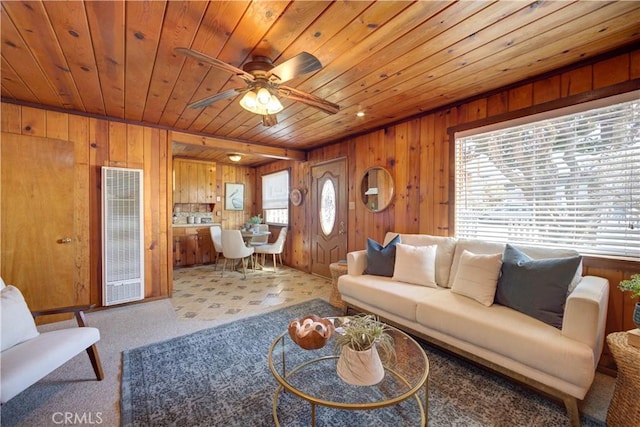 living area with ceiling fan, wood walls, and wood ceiling