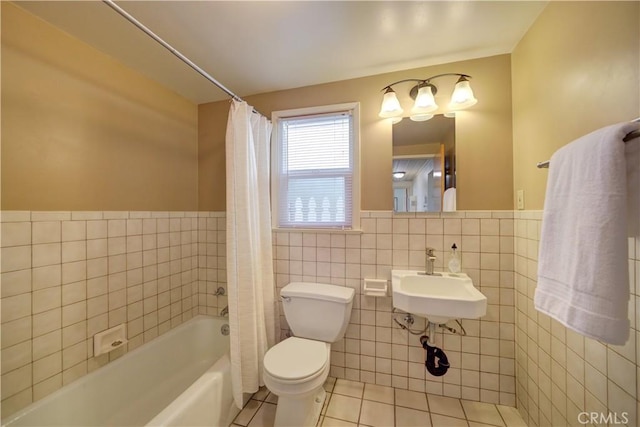 bathroom with toilet, a washtub, a sink, tile walls, and tile patterned floors