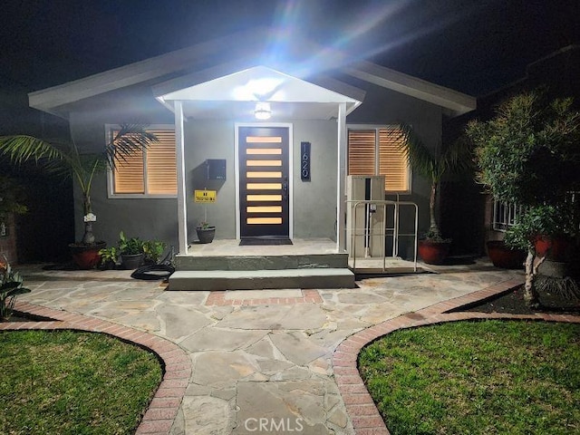 entrance to property with a patio area and stucco siding