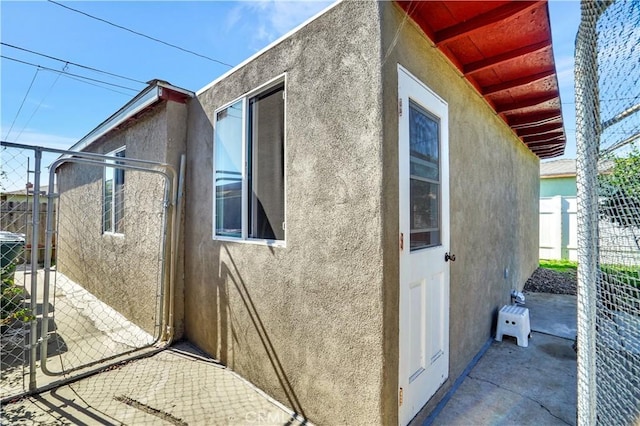 view of home's exterior featuring a gate, fence, and stucco siding