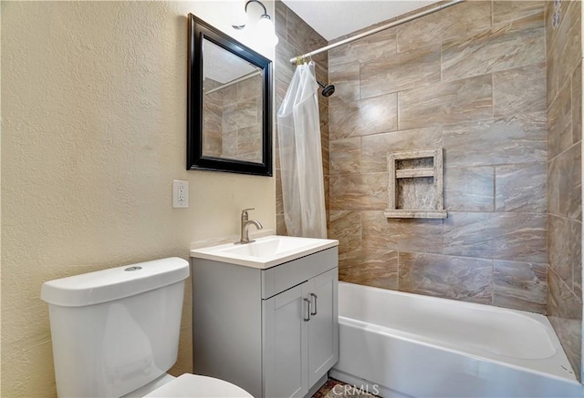 full bath with a textured wall, vanity, shower / bath combo with shower curtain, and toilet