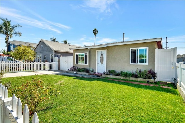 ranch-style house featuring a front lawn, fence private yard, and stucco siding