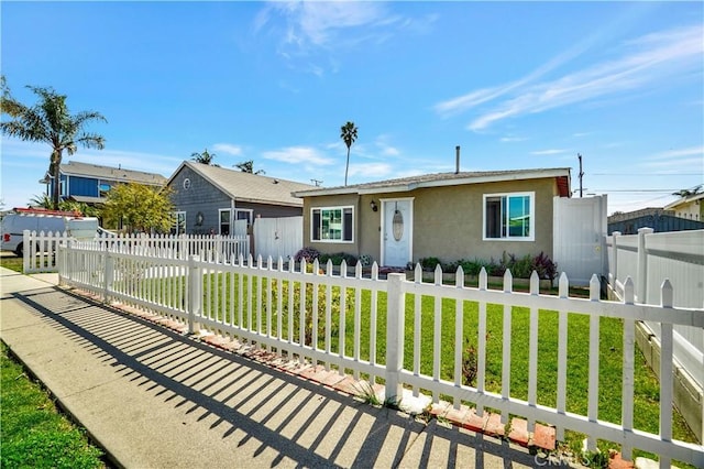 view of front facade featuring a fenced front yard, a front lawn, and stucco siding