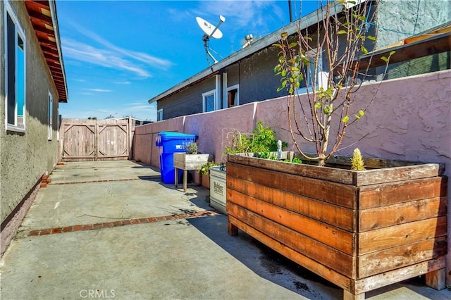 view of side of property with a patio area, fence, and stucco siding