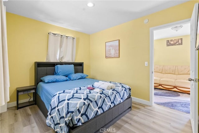 bedroom featuring light wood-type flooring and baseboards