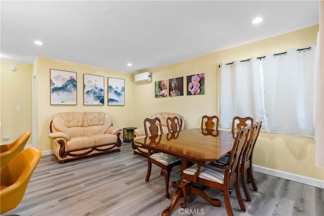 dining room with recessed lighting, an AC wall unit, baseboards, and wood finished floors