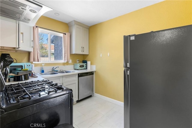 kitchen featuring baseboards, range hood, light countertops, black appliances, and a sink