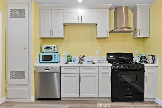 kitchen featuring black gas range oven, stainless steel dishwasher, white microwave, a sink, and wall chimney range hood