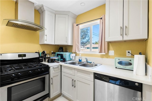 kitchen featuring white cabinets, appliances with stainless steel finishes, ventilation hood, light countertops, and a sink