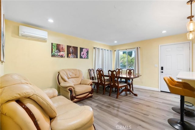 living area with light wood-style floors, recessed lighting, a wall mounted air conditioner, and baseboards