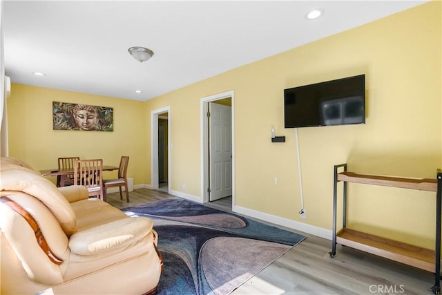 living room featuring baseboards, wood finished floors, and recessed lighting