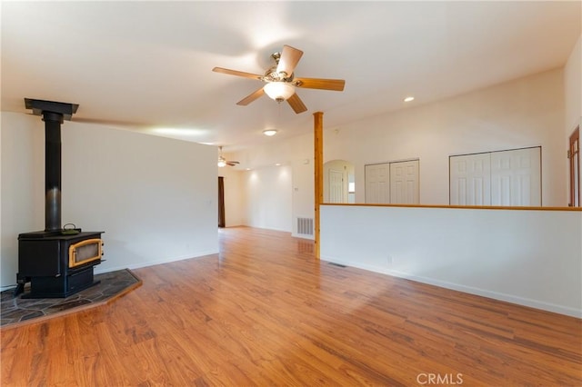 12625 Elk Mountain Rd, Upper Lake, CA 95485 - unfurnished living room with wood finished floors, a wood stove, baseboards, visible vents, and ceiling fan