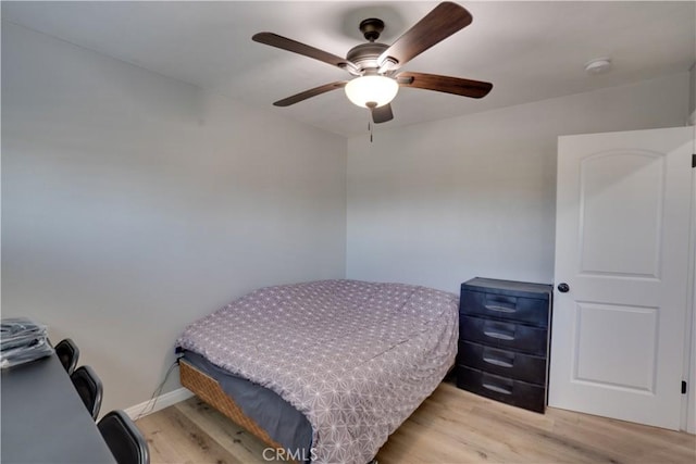 bedroom featuring ceiling fan, light wood-type flooring, and baseboards