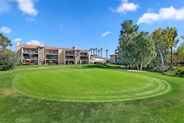 surrounding community with a yard and golf course view